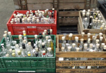 Viele Flaschen mit Destillaten in Holzkisten.