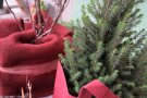 Weihnachtliche Deko mit rotem Wollvlies um grüne Nadelzweige