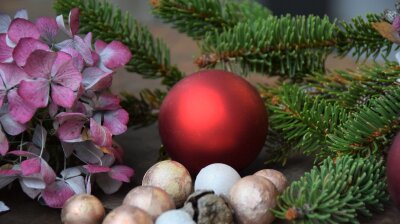 Weihnachtsdekoration mit roter Kugel und Nadelzweig