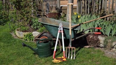 Gartenwerkzeuge mit Schubkarre stehen beieinander