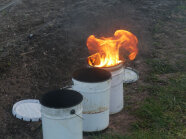 Ein von drei brennender Eimer mit gefülltem Wachs steht auf den Boden zum Einsatz