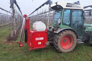 Kaltnebelgerät am Schlepper ausgestattet am Pflanzstreifen der Obstbäume.