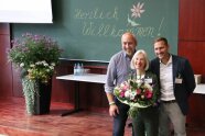 Gruppenbild Eva-Maria Geiger mit Blumenstrauß und beiden Herren nebeneinander.