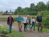 Das Forschungsteam des Kompetenzzentrums Ökogartenbau der LWG in Bamberg läuft vor einem Feld.