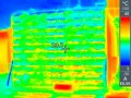 Wärmebildaufnahme der Südwand mit begrüntem Rinnensystem. Die Farbcodierung zeigt eine deutlich niedrigere Temperatur in der Begrünung im Vergleich zur unbegrünten Hauswand im Hintergrund.