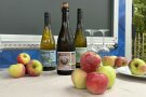 3 Flaschen Cidre, Äpfel mit Gläsern schön präsentiert auf der LGS. 