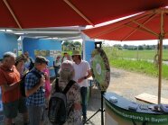 Beratung einer Gruppe unter roten Sonnenschirmen mit einem Glücksrad