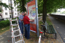 Montage des bürgernahen Infoleitsystems zum Versuch luft- und wasserdurchlässige Geh- und Radwege an der Teststrecke Ludwigkai in Würzburg.