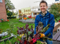 Florian Demling steht auf einer Urban-Gardening-Demofläche vor einem Hochbeet.