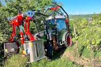 Ein Weinbergstraktor davor angebauter Technik mit Metallrahmen und Luftschläuchen